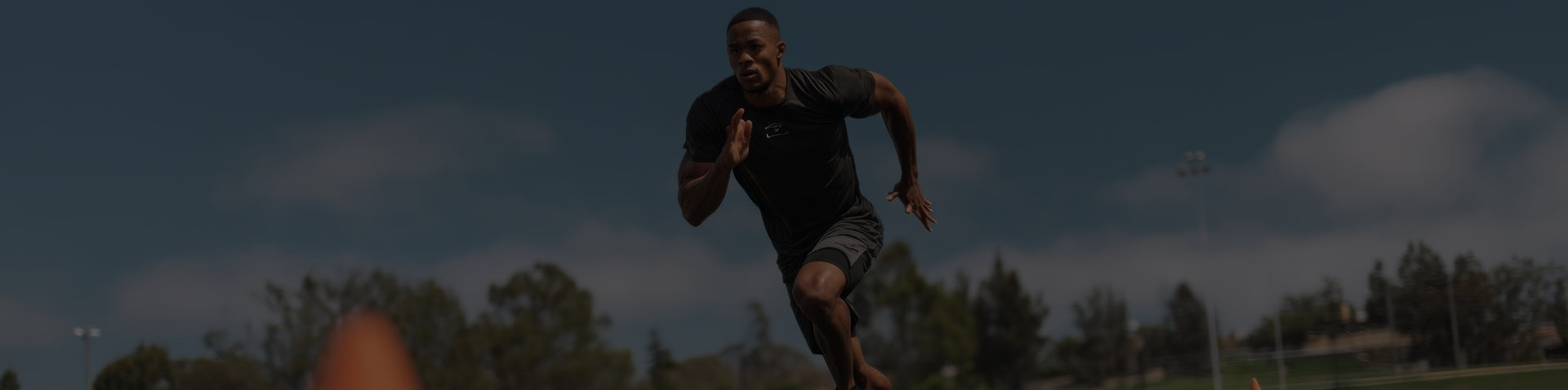 Person playing baseball on a field with trees in the background